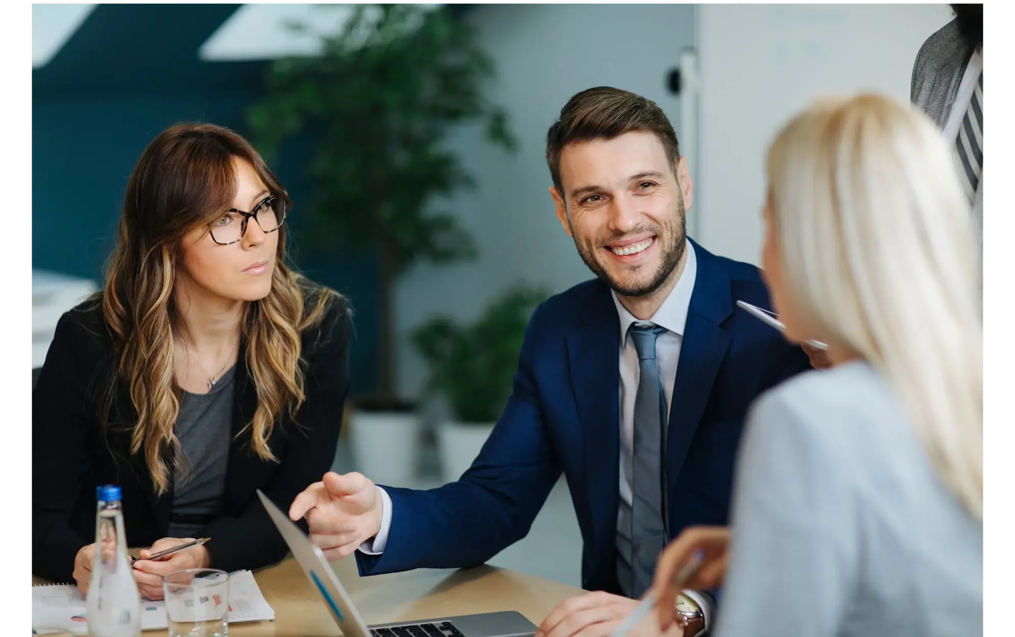 Two advisors in conversation with a client across a table